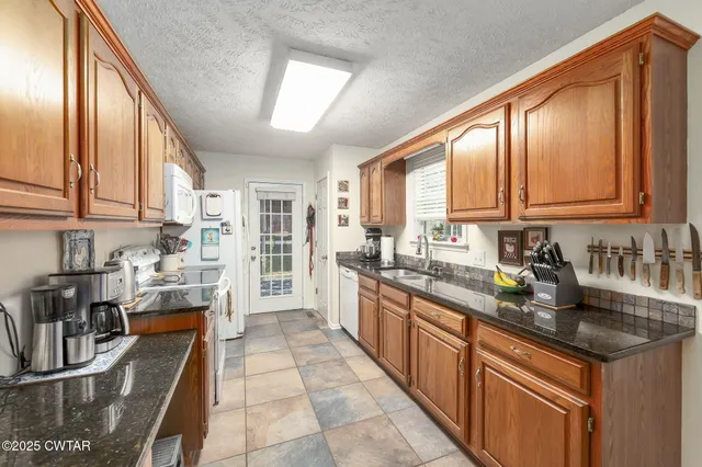 a large kitchen with stainless steel appliances granite countertop a sink stove and cabinets