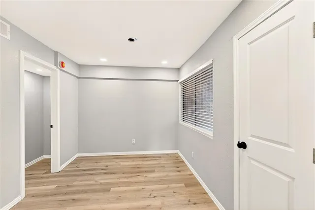 a view of a room with wooden floor and windows