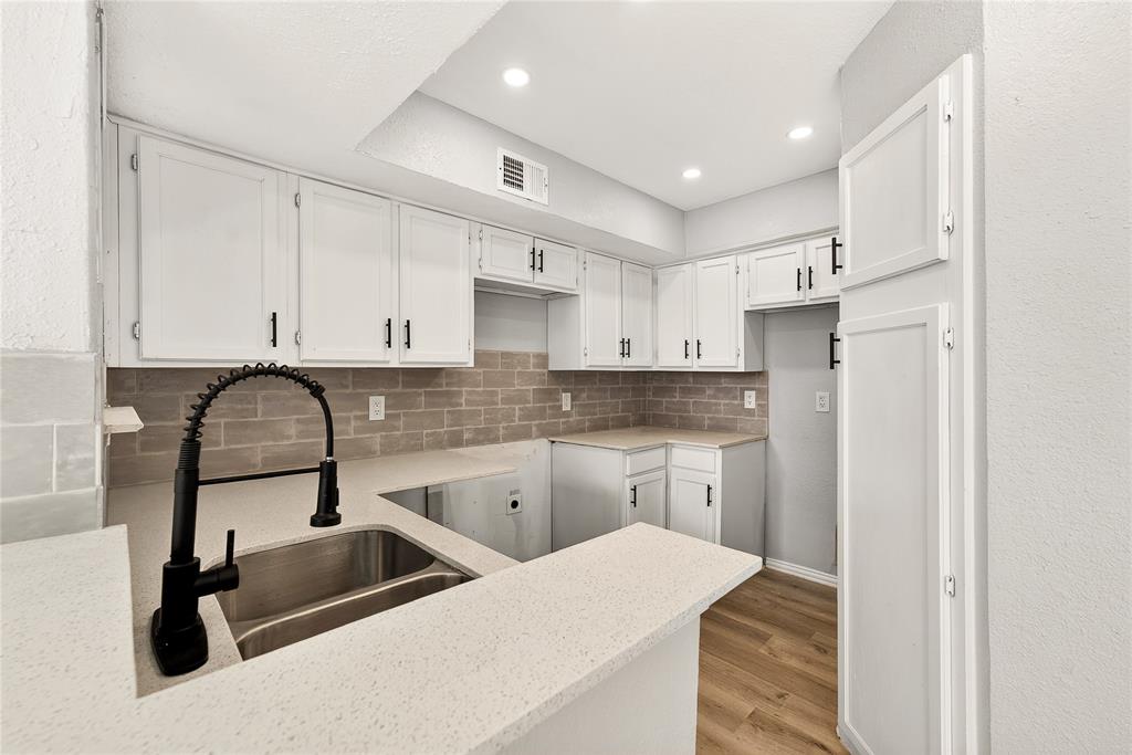 9801 Walnut Street, Unit 212 Dallas, TX 75243 - Photo 4 of 16 a kitchen with stainless steel appliances a sink dishwasher a refrigerator and cabinets with wooden floor