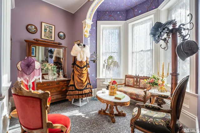 a living room with furniture a rug and a floor to ceiling window