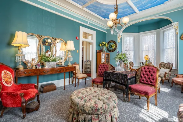 a living room with furniture a chandelier and a large window
