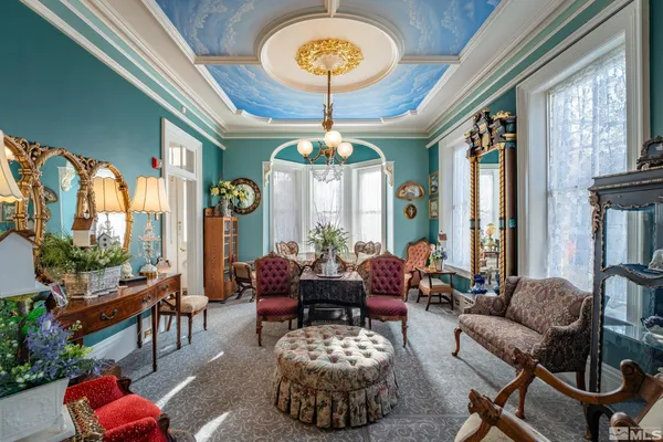 a living room with furniture a chandelier and a large window