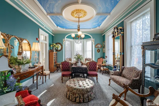 a living room with furniture a chandelier and a large window