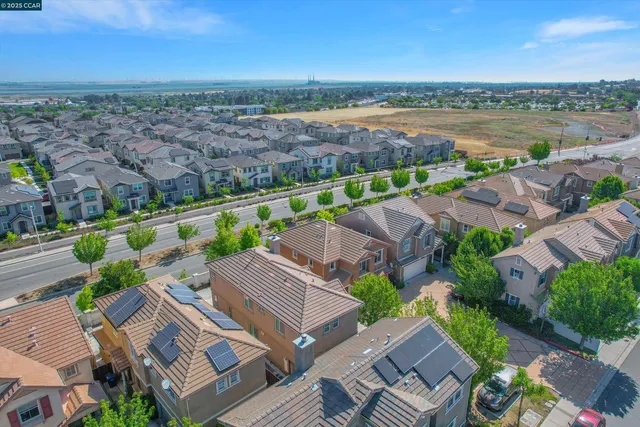 an aerial view of a city with lots of residential buildings and mountain view in back