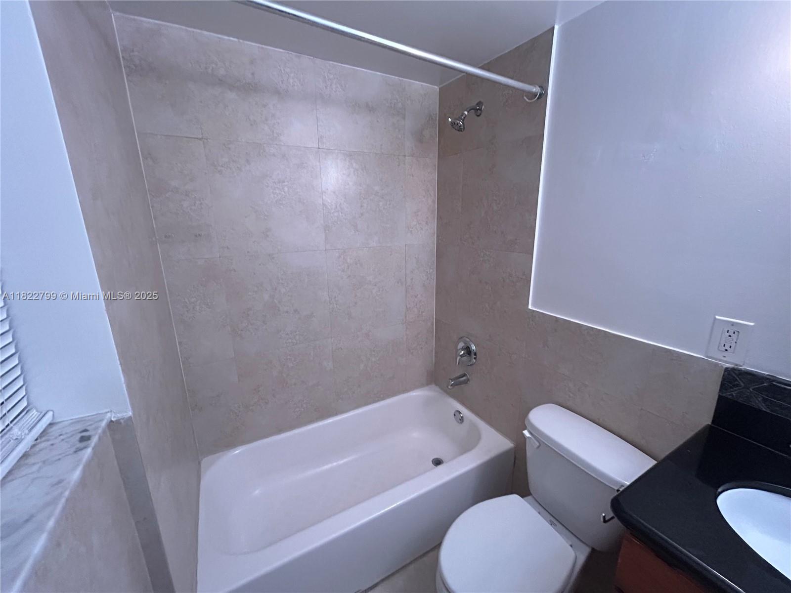 2880 Pine Tree Drive, Unit 1 Miami Beach, FL 33140 - Photo 11 of 13 a bathroom with a toilet and a bathtub
