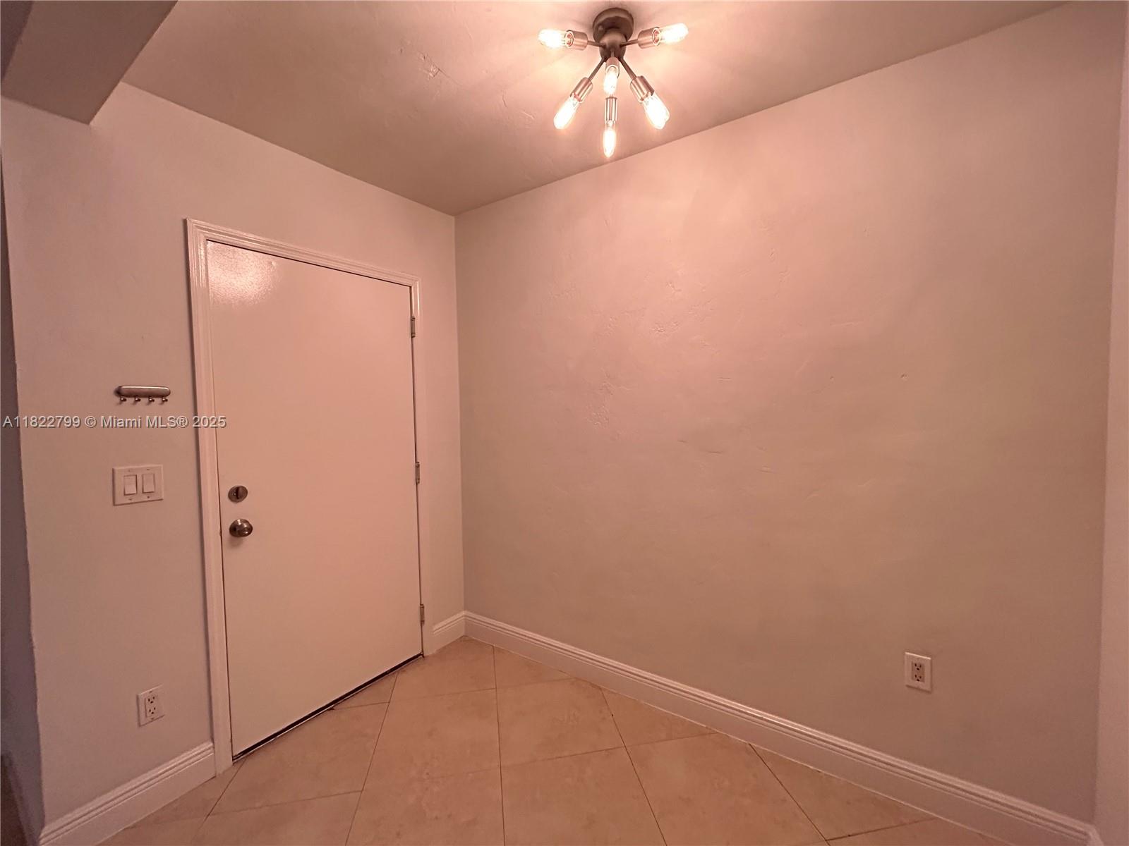 2880 Pine Tree Drive, Unit 1 Miami Beach, FL 33140 - Photo 5 of 13 an empty room with a empty space and a ceiling fan