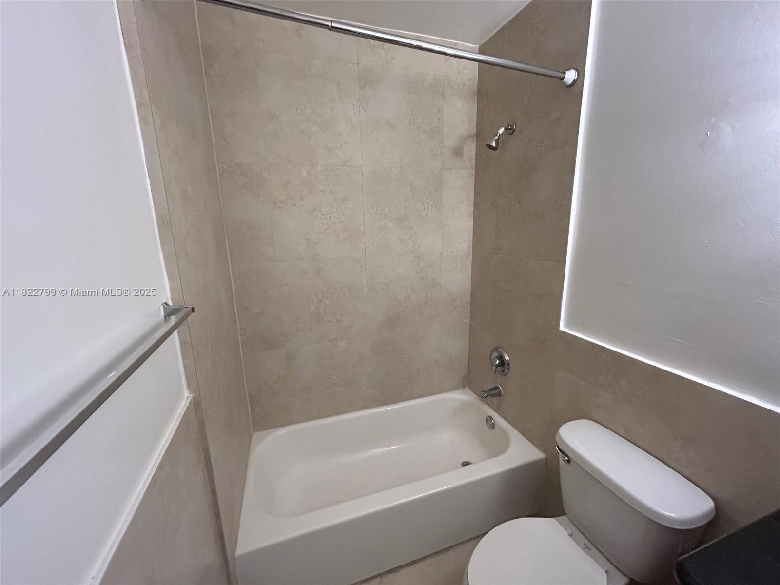 2880 Pine Tree Drive, Unit 1 Miami Beach, FL 33140 - Photo 9 of 13 a bathroom with a toilet and a bathtub
