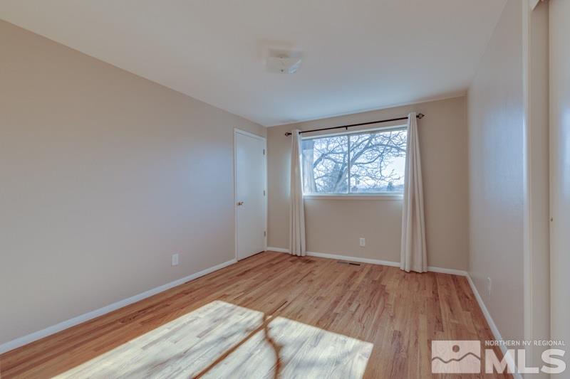 1755 Carlin Street Reno, NV 89503 - Photo 12 of 26 wooden floor in an empty room with a window