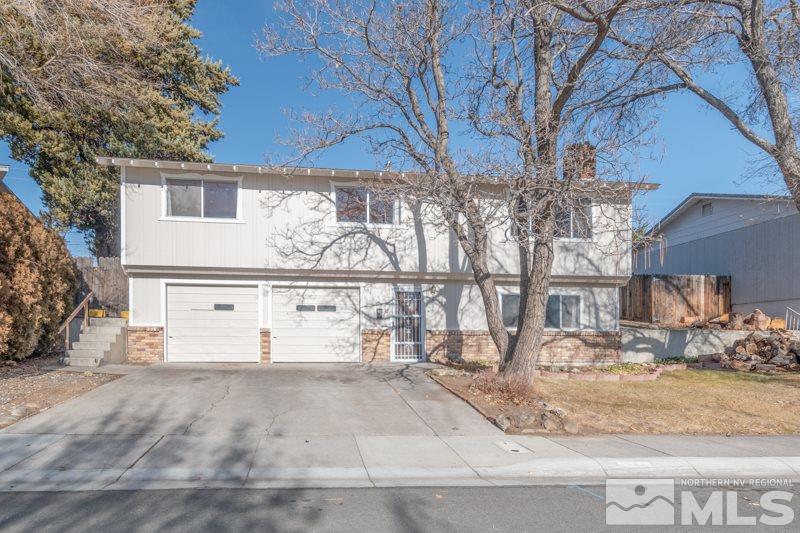 1755 Carlin Street Reno, NV 89503 - Photo 26 of 26 a view of a white house with a large tree covered with wooden fence