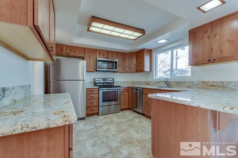 1755 Carlin Street Reno, NV 89503 - Photo 4 of 26 a kitchen with granite countertop a refrigerator and a sink