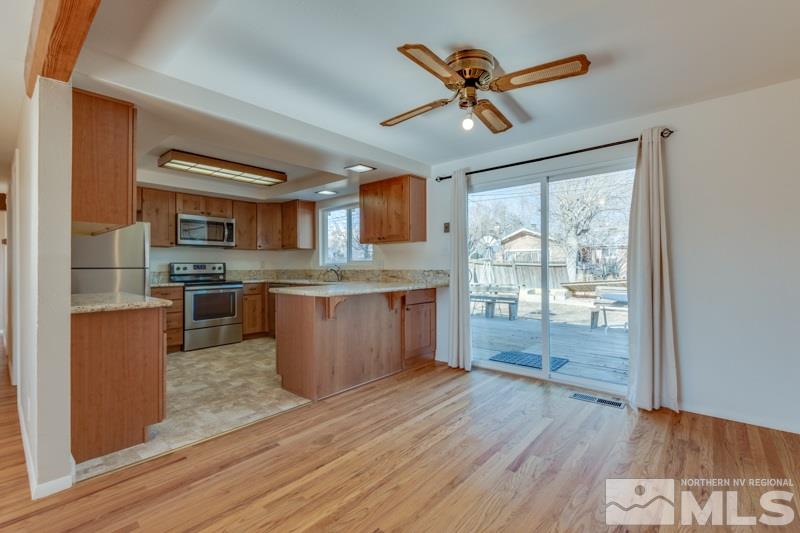1755 Carlin Street Reno, NV 89503 - Photo 5 of 26 a kitchen with stainless steel appliances granite countertop a refrigerator a stove top oven a sink with wooden floor and cabinets