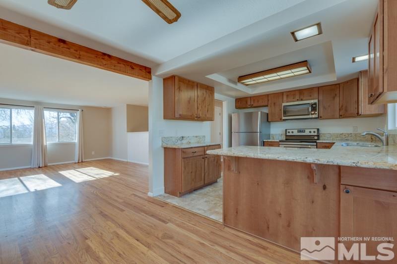 1755 Carlin Street Reno, NV 89503 - Photo 7 of 26 a kitchen with stainless steel appliances granite countertop a stove a sink and a refrigerator
