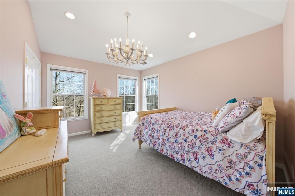 22 Falling Waters Oakland, NJ 07436 - Photo 21 of 43 a bedroom with a bed and a chandelier