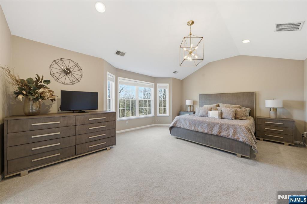 22 Falling Waters Oakland, NJ 07436 - Photo 23 of 43 a spacious bedroom with a bed a flat screen tv and a window
