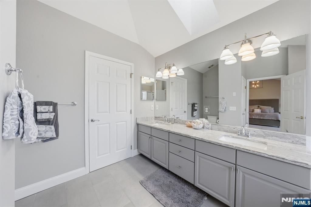 22 Falling Waters Oakland, NJ 07436 - Photo 25 of 43 a bathroom with double vanity sinks a vanity a lamp and a mirror