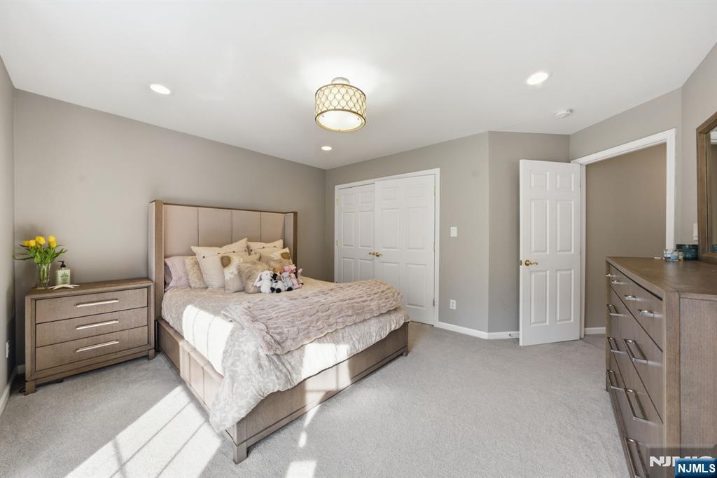 22 Falling Waters Oakland, NJ 07436 - Photo 29 of 43 a bedroom with a bed and a chandelier