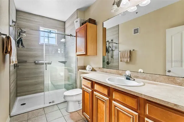a bathroom with a shower sink vanity and toilet