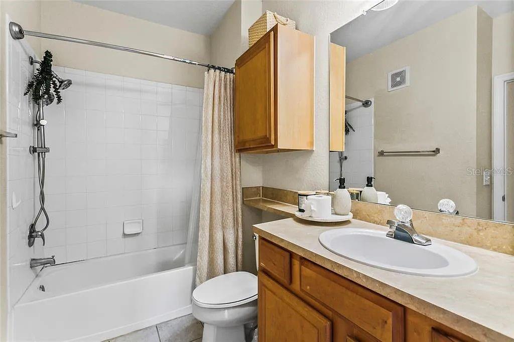 6105 Metrowest Boulevard, Unit 103 Orlando, FL 32835 - Photo 7 of 14 a bathroom with a granite countertop sink toilet and shower