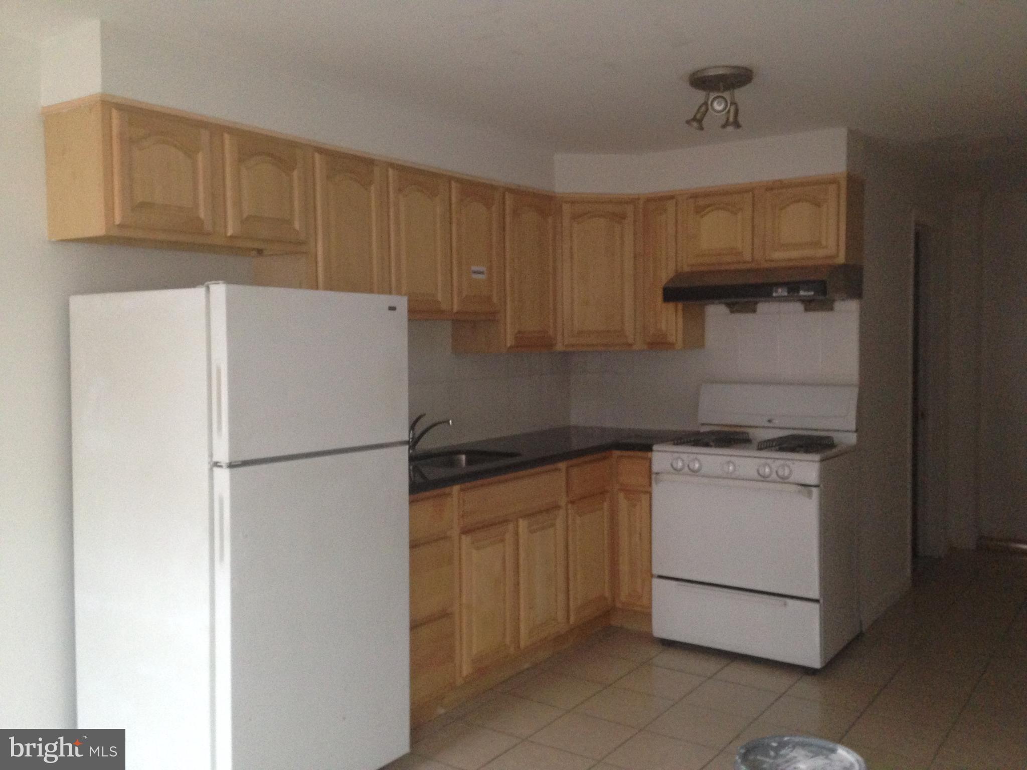 1303 South 8th Street Philadelphia, PA 19147 - Photo 20 of 22 a kitchen with a refrigerator sink stove and cabinets