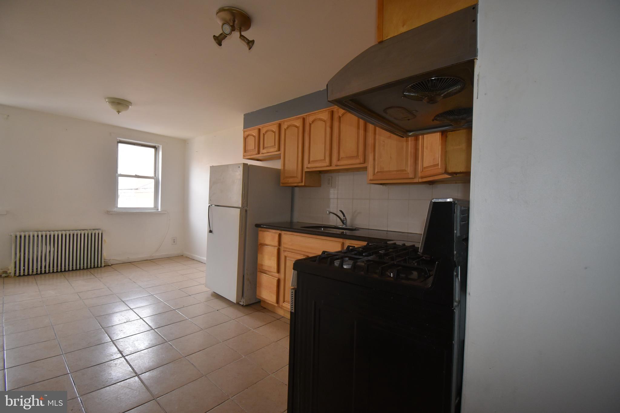 1303 South 8th Street Philadelphia, PA 19147 - Photo 5 of 22 a kitchen with a refrigerator a stove and a window