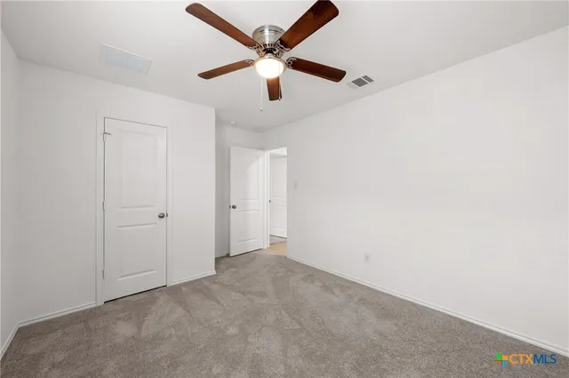 an empty room with a ceiling fan and a window