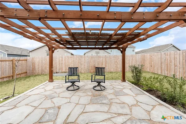 a view of swimming pool with a table and chairs in patio