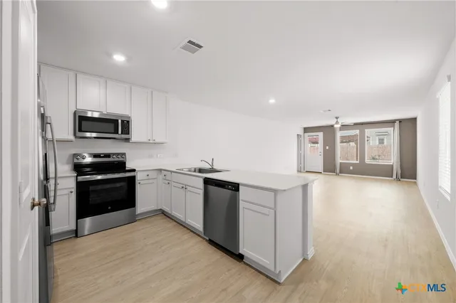 a kitchen with stainless steel appliances kitchen island granite countertop a stove a sink and a refrigerator