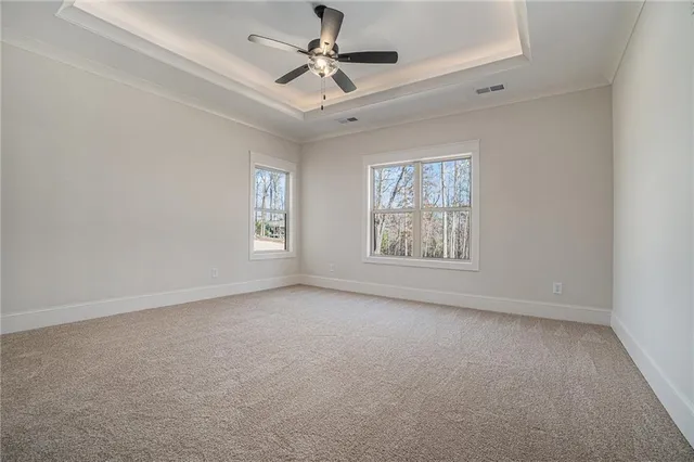 en empty room with windows and ceiling fan