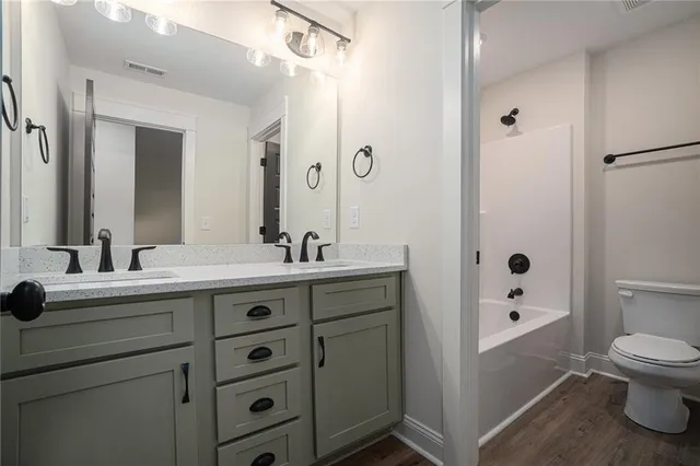 a bathroom with a sink a toilet a shower and a mirror