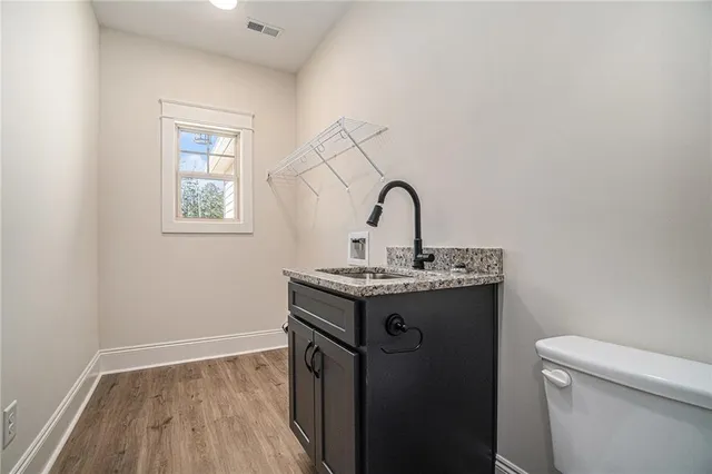 a room with a sink a toilet and window