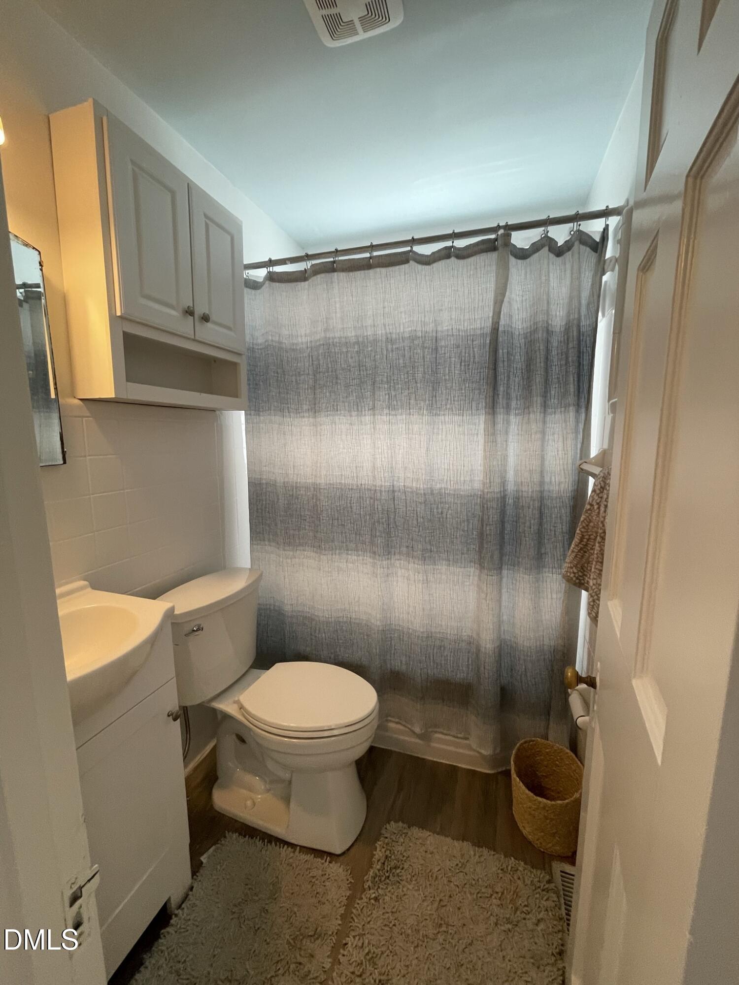 1009 Canterbury Road Raleigh, NC 27607 - Photo 13 of 31 a bathroom with a granite countertop toilet and a shower