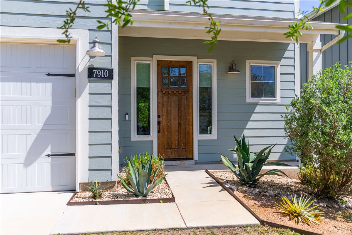 7910 Ryans Way Austin, TX 78726 - Photo 3 of 39 A charming front entry welcomes you with soft blue siding, clean architectural lines, and a warm natural wood front door.