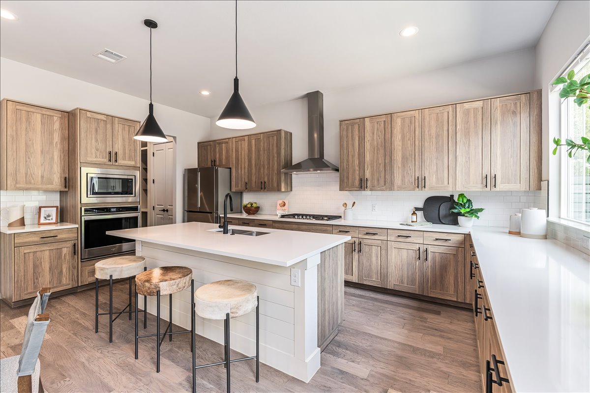 7910 Ryans Way Austin, TX 78726 - Photo 9 of 39 The modern kitchen features a large center island with seating, perfect for casual dining or entertaining.