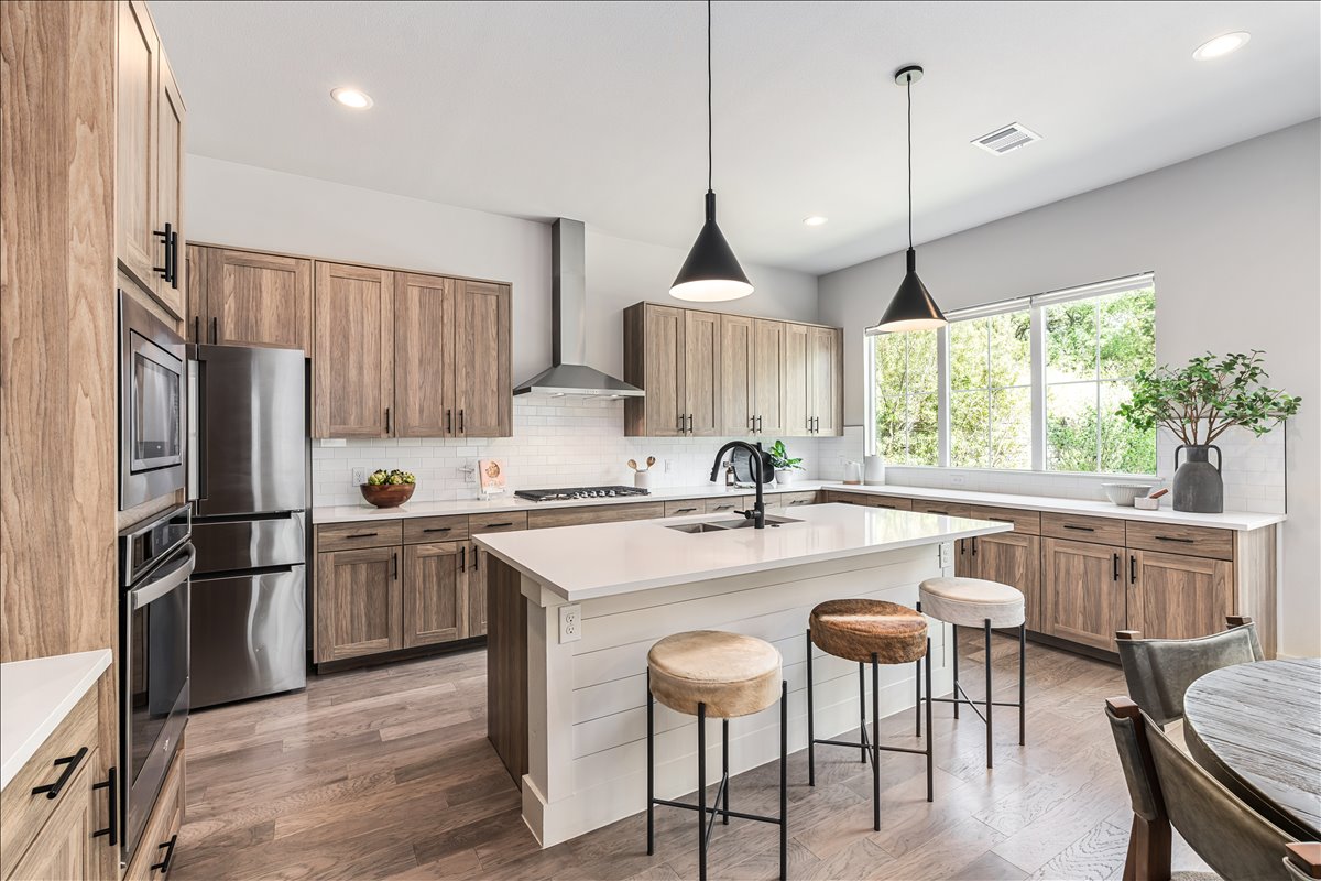7910 Ryans Way Austin, TX 78726 - Photo 10 of 39 The spacious island anchors the kitchen and connects seamlessly to the dining and living areas.
