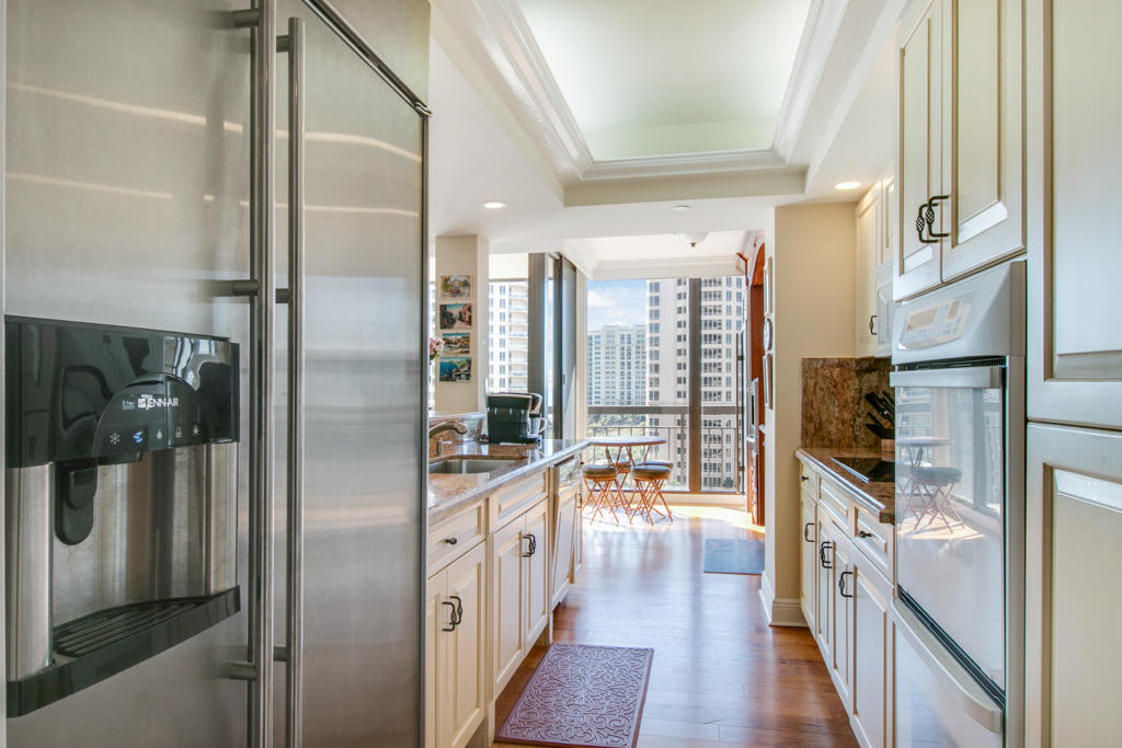 4100 North Ocean Drive, Unit 1002 Singer Island, FL 33404 - Photo 12 of 37 a kitchen with stainless steel appliances a refrigerator and a view of living room
