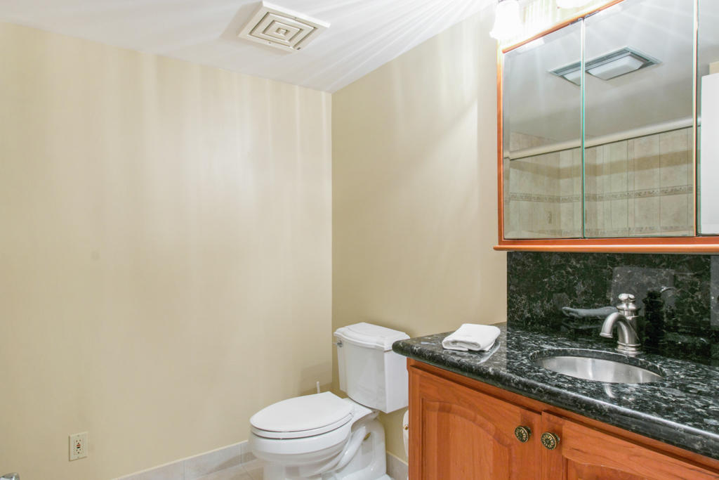4100 North Ocean Drive, Unit 1002 Singer Island, FL 33404 - Photo 23 of 37 a bathroom with a granite countertop sink toilet and a mirror
