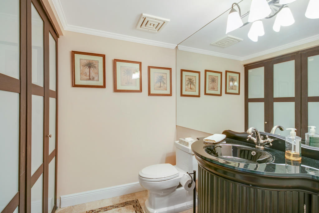 4100 North Ocean Drive, Unit 1002 Singer Island, FL 33404 - Photo 29 of 37 a bathroom with a granite countertop sink mirror vanity and toilet