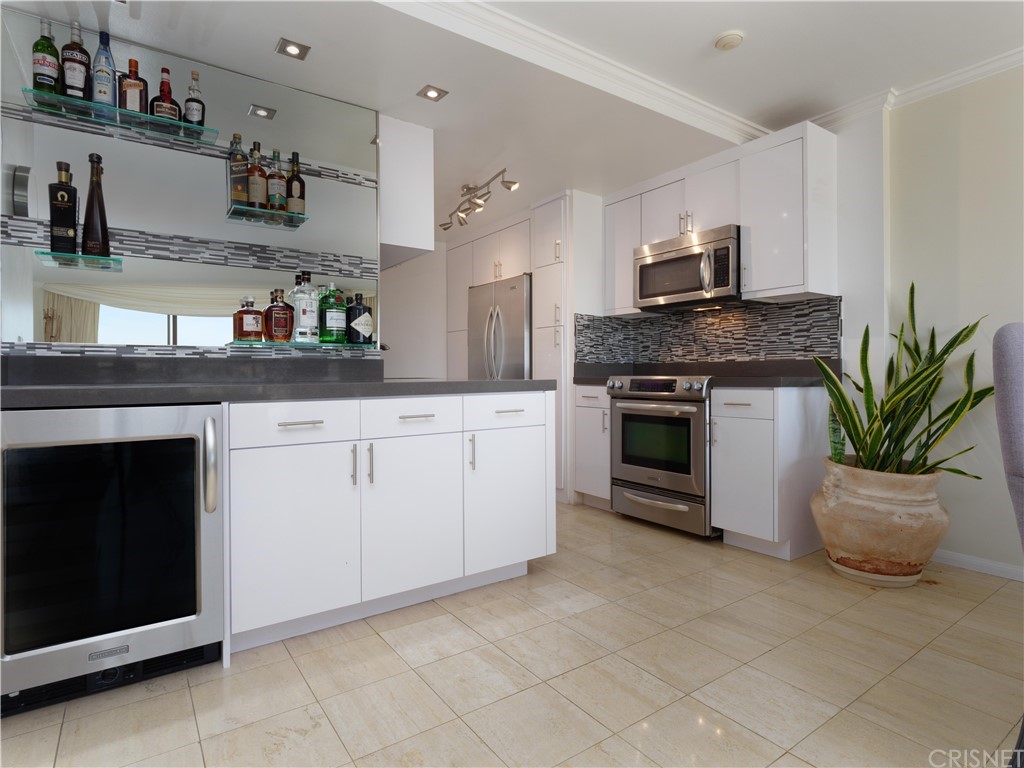 531 Esplanade, Unit 913 Redondo Beach, CA 90277 - Photo 15 of 42 a kitchen with granite countertop a stove a sink and a white cabinets
