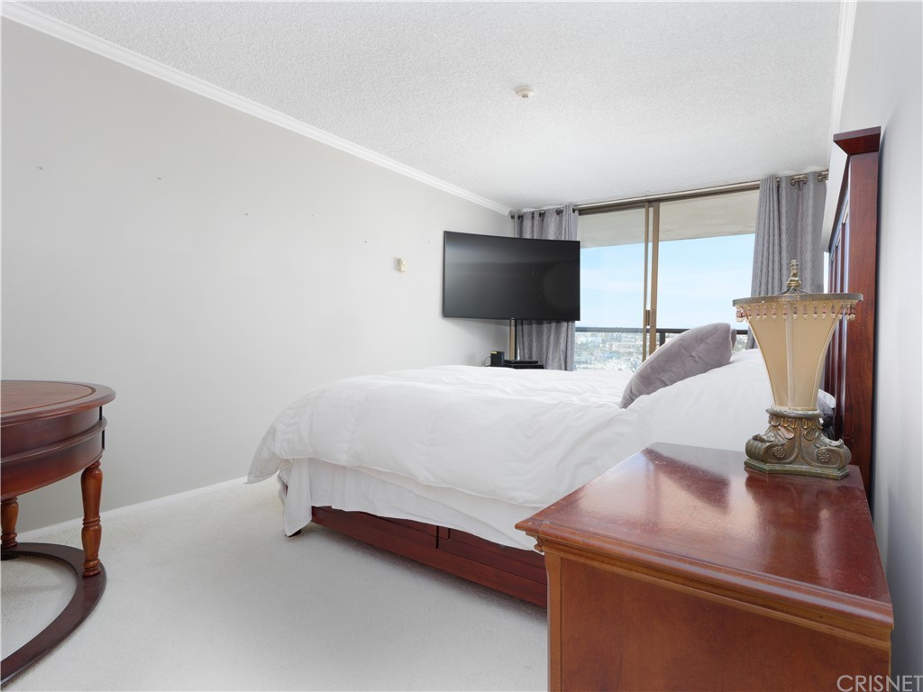 531 Esplanade, Unit 913 Redondo Beach, CA 90277 - Photo 27 of 42 a bedroom with a bed and a flat screen tv