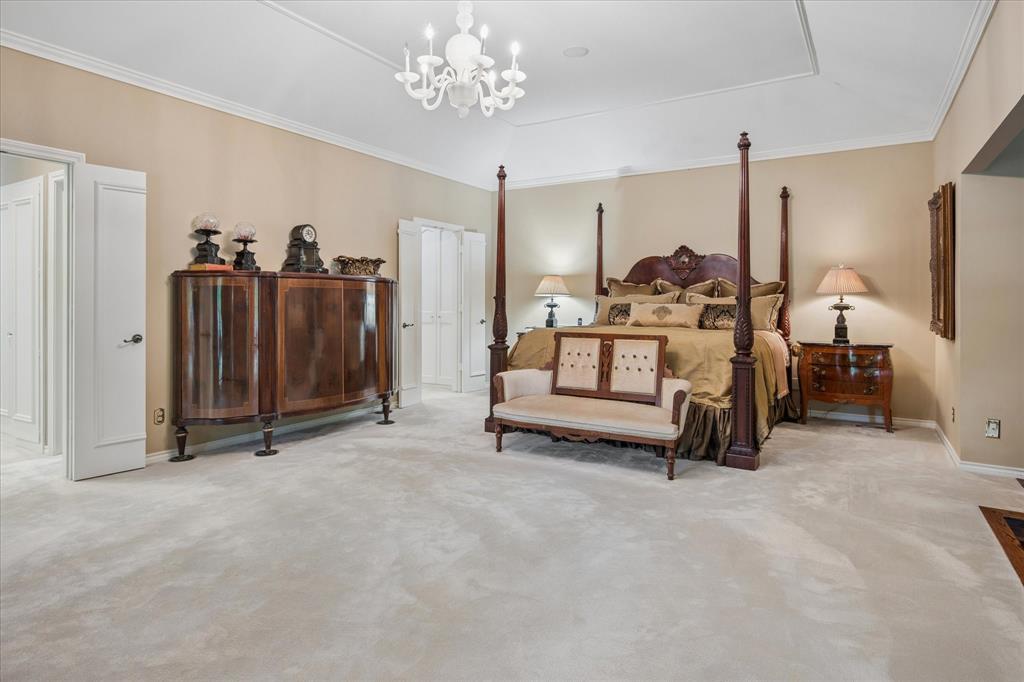 7276 Lupton Circle Dallas, TX 75225 - Photo 24 of 40 a spacious bedroom with furniture and a chandelier