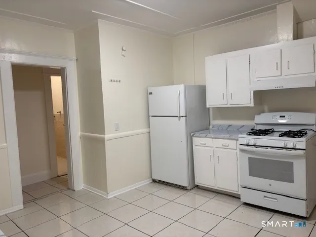 a kitchen with white cabinets and white appliances