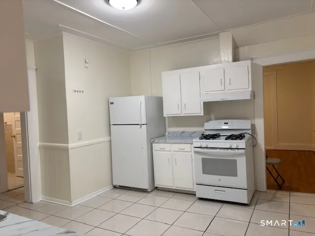 a kitchen with white cabinets and white appliances