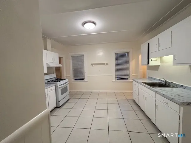 a large kitchen with a stove a sink dishwasher and a refrigerator