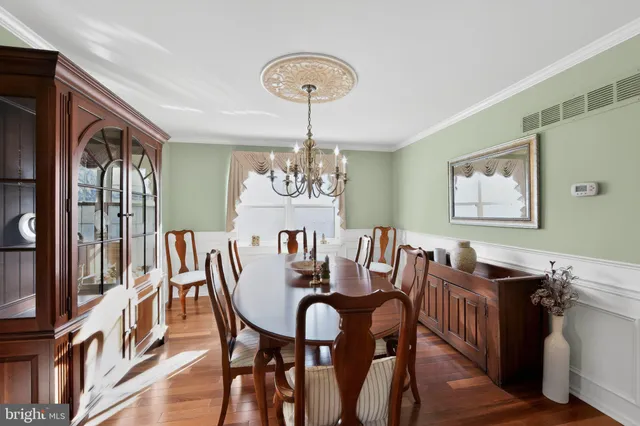 a view of a dining room with furniture a chandelier and wooden floor