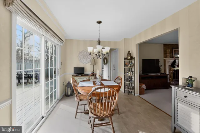 a dining room with furniture a chandelier and window