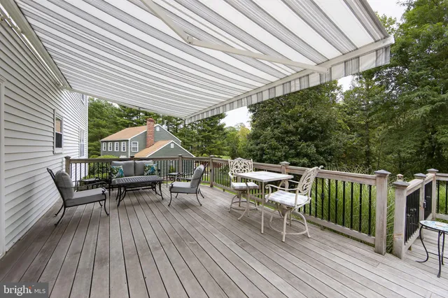 a view of a roof deck with table and chairs a barbeque with wooden floor and fence