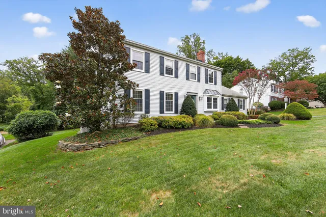 a front view of a house with a yard and green space