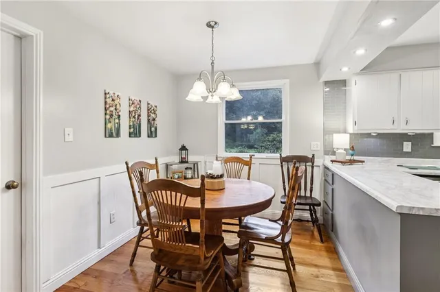 a dining room with furniture a chandelier and window