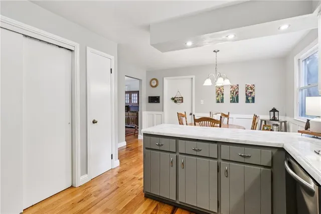 a view of cabinets a sink and dishwasher with wooden floor