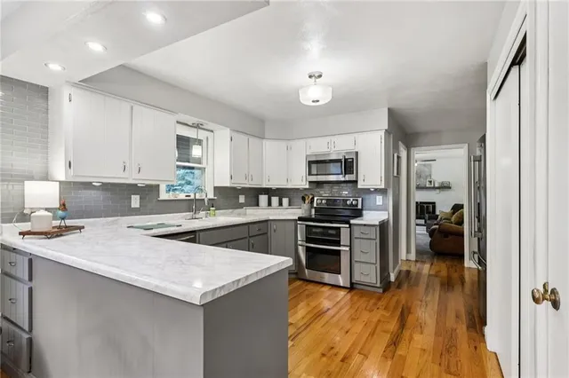a kitchen with a refrigerator a stove top oven a sink dishwasher and wooden cabinets